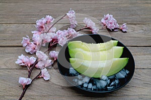 Melon sliced with ice on wood background