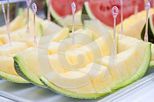 Melon sliced on a tray with a dipper