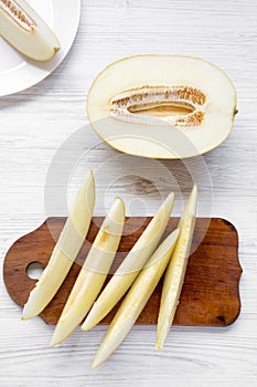 Melon slices over white wooden background