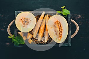 Melon in a wooden box. Sliced to pieces of melon. On a wooden background. Free space for text.