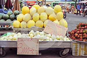 Melons on stalls with price tags at a street market in Cho Lon, Ho Chi Minh City, Vietnam