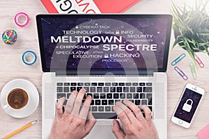 Meltdown and spectre threat concept on top view laptop screen with mans hands on office desk