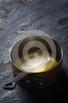 Melted butter in the stewpan on the stone background