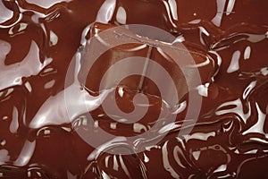 Melted chocolate and pieces of chocolate bar as a background closeup