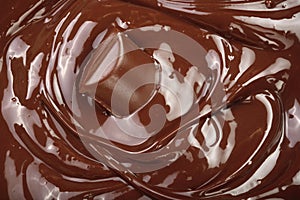 Melted chocolate and pieces of chocolate bar as a background closeup