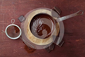 Melted chocolate swirl in pan on the wooden background