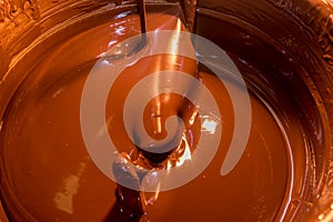 Melted dark chocolate in machine for tempering chocolate photo