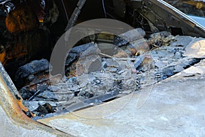 Melted head restraints and rear window of burned out car