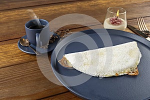 Melted mozzarella cheese tapioca, next to a cup of black coffee. Traditional Brazilian food_2