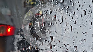 Melted snow and rain drops on the windshield of a car. Blurred outdoor view, winter season sleet as seen out of vehicle window