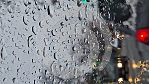 Melted snow and rain drops on the windshield of a car. Blurred outdoor view, winter season sleet as seen out of vehicle window