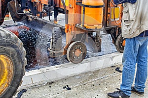 Melting asphalt with paver machine and placing gravel