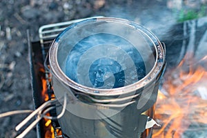 Melting black tar over fire in a can of smoke