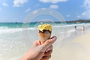 Melting ice cream on beach in summer hot weather ocean landscape nature outdoor vacation , Yellow ice cream mango with nuts / Ice