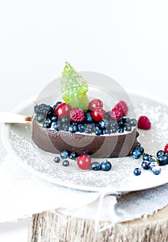 Melting ice cream with chocolate glaze and berries.