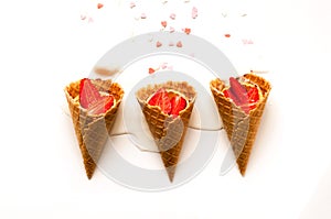 Melting ice cream in waffle cones with strawberries on white background. National ice cream day 19 july concept. Close-up