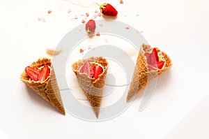 Melting ice cream in waffle cones with strawberries on white background. National ice cream day 19 july concept. Creative copy