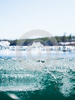 Melting ice crystals on surface of clear-watered lake