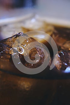 Melting ice cube in a drink cola - close-up