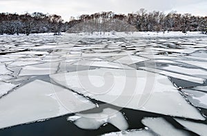 Melting ice floes on surface of river in twilight