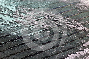 Melting ice on the rear window of the car. Close-up view of electric window heating with contact strips