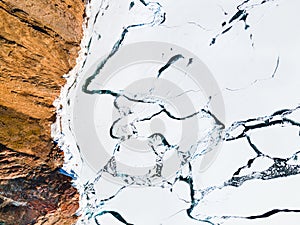 Melting ice on the shore of Baikal lake in spring. Aerial top down view