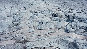 Melting ice and snow of a glacier on a rock in Norway. Close-up aerial shot, UHD