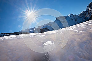 Melting ice and snow, mountain landscape with blue sky and bright sun