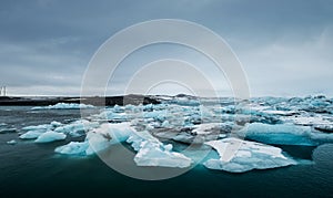 Melting ice on the water in Jokulsarlon lake in south Iceland in cloudy day. Global warming