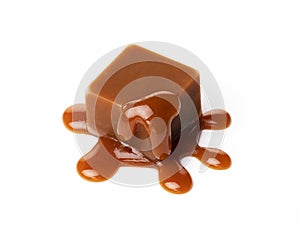 A melting piece of milk chocolate on a white background