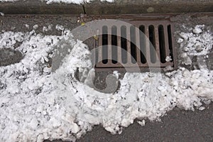 1 - Melting snow flows into an iron kerbside surface drain photo