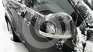 Melting snow and ice from the car. Car`s side view mirror