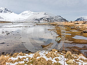 Melting snow and ice, low tide in Flakstadpollen bay, Flakstadoya, Lofoten islands, Nordland, Norway