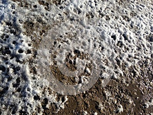 Melting snow on the muddy road