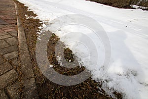 Melting snow on side of road by curb