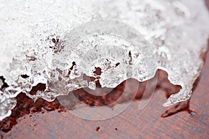 Melting snow, icicles and ice as a background. Outgoing winter, spring weather