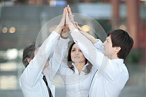 Members of the business team giving each other a high-five,standing in the office