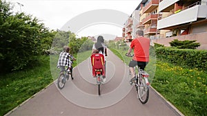 Members Of Happy Family Spending Time Together Outdoors. They Have A Lot of Fun Riding On Bikes.