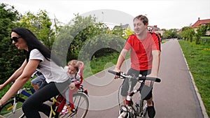 Members Of Happy Family Spending Time Together Outdoors. They Have A Lot of Fun Riding On Bikes.