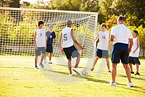 Members Of Male High School Soccer Playing Match