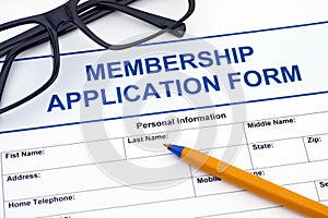 Membership application form with pen and glasses