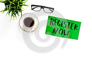 Membership concept. Template for registration. Register now hand lettering iconon word desk with glasses, coffee, plant