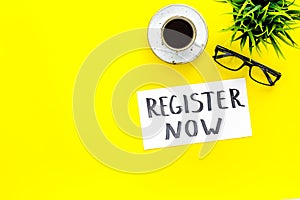 Membership concept. Template for registration. Register now hand lettering iconon word desk with glasses, coffee, plant