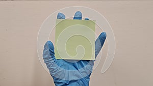 Memo paper in a hand wearing surgical rubber glove