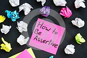 Memo with sign How to be Assertive