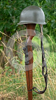 Memorial battlefield cross. Symbol of a fallen US soldier. M1 rifle with helmet