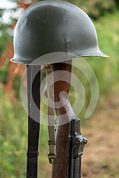 Memorial battlefield cross. Symbol of a fallen US soldier. M1 rifle with helmet