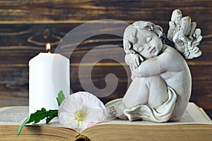 Memorial candle, angel figurine and flower