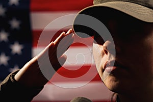 Memorial day. A female soldier in uniform salutes against the background of the American flag. Close-up portrait. The concept of