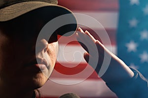 Memorial day. A female soldier in uniform salutes against the background of the American flag. Close-up portrait. Copy space. The